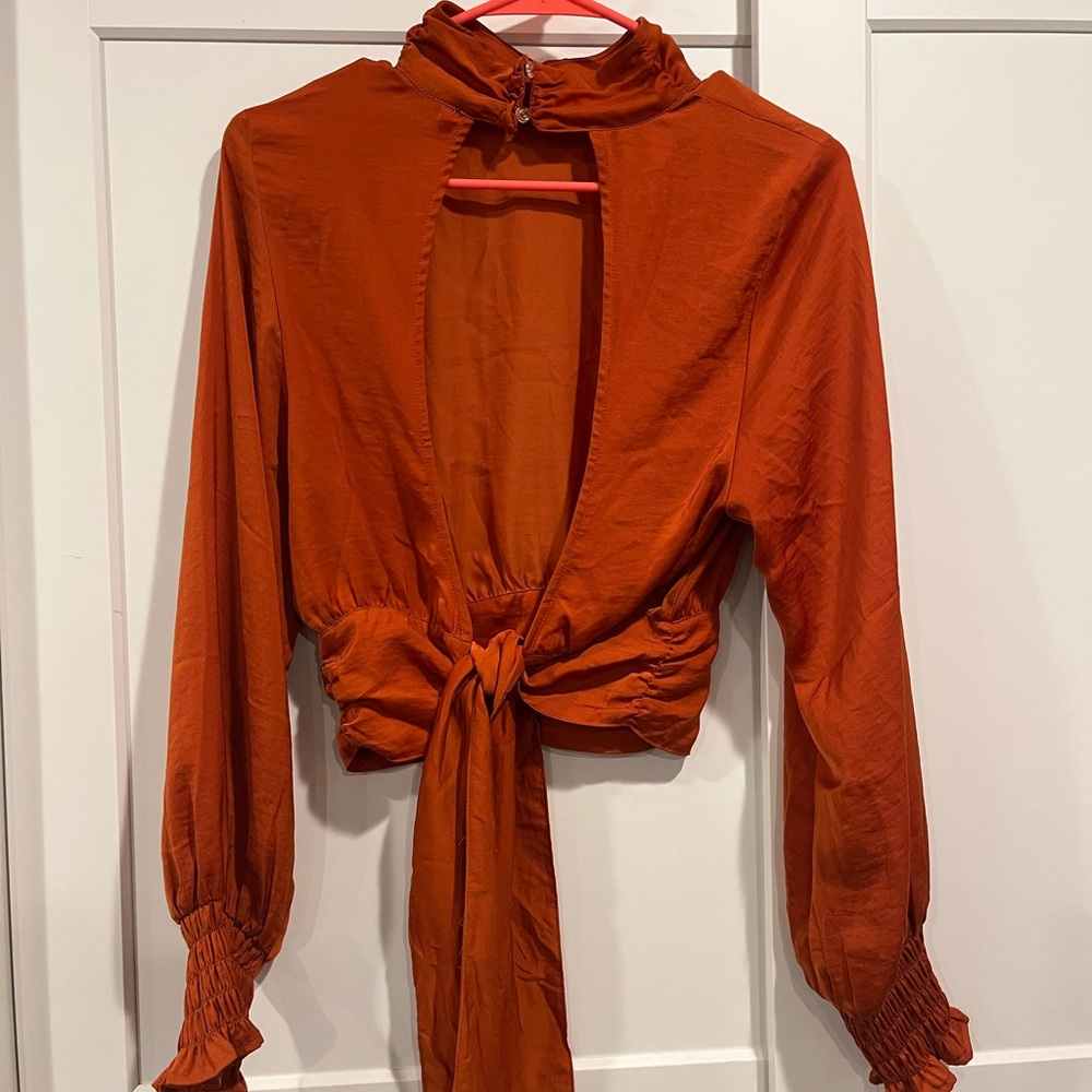 Orange mock neck blouse with puff sleeves and tie front